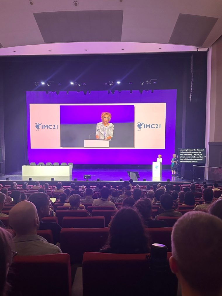 A speaker addressing delegates from the podium at the IMC21 opening ceremony